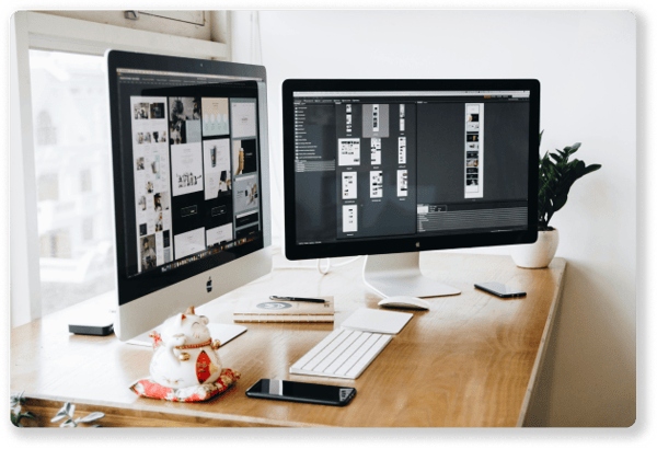 two computer monitors with website design mock ups